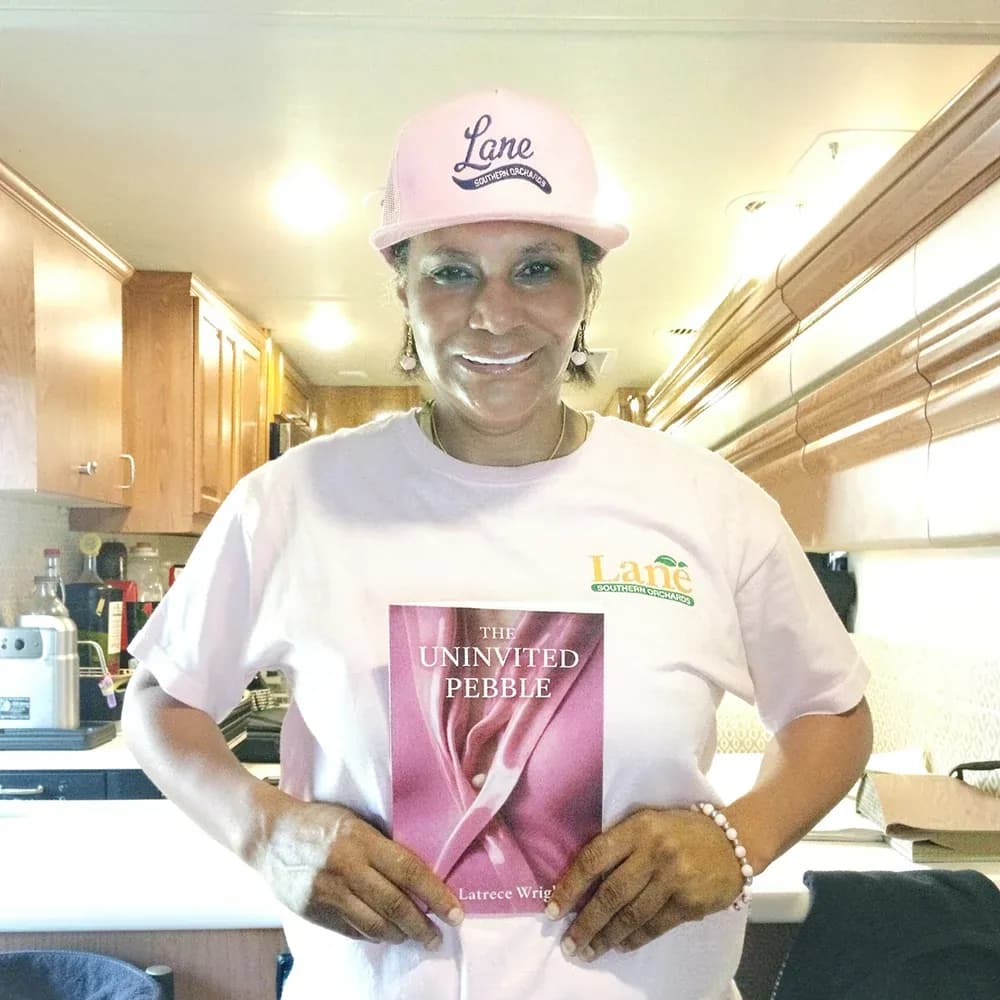 Dr. Latrece Wright holding her book The Uninvited Pebble